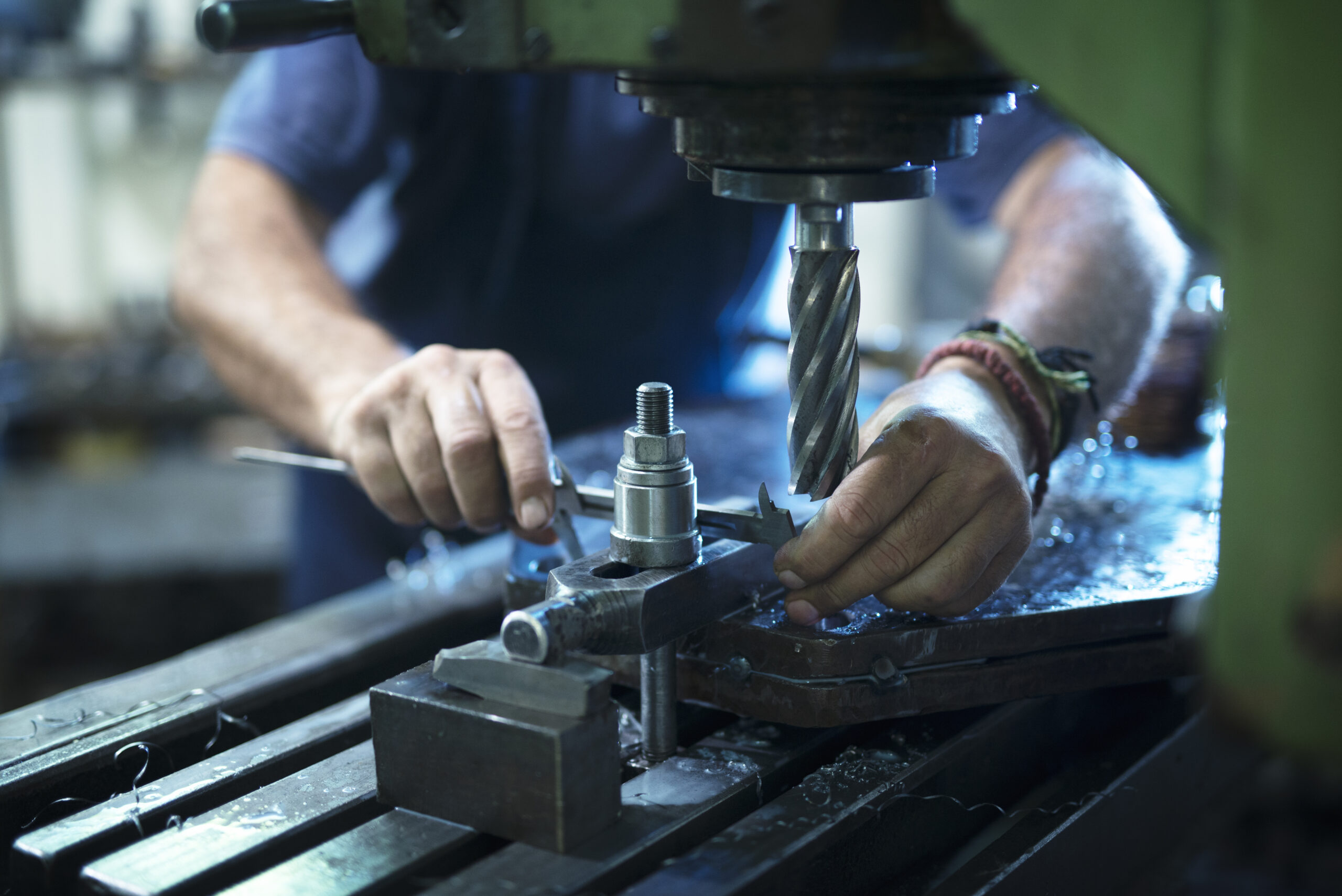 worker operating industrial machine in metal workshop.